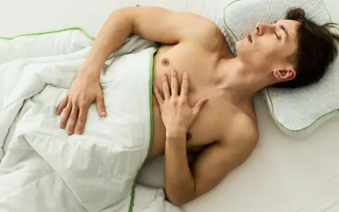 Ein Mann schläft entspannt unter einer Decke, ohne Unterhose schlafen für maximalen Komfort.