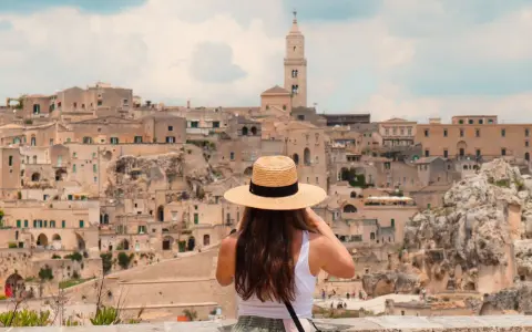 A woman in a straw hat captures the ancient city of Matera, a highlight of her southern tour of Italy.
