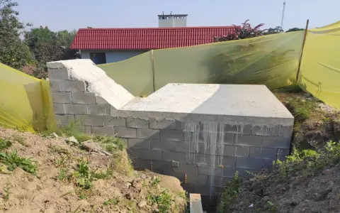 Budowa ziemianki: betonowy fundament i ściany z bloczków, gotowe do dalszych prac.
