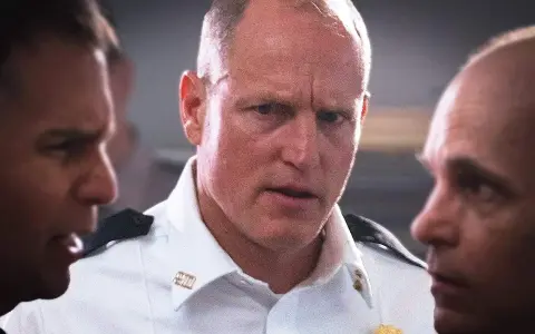 Woody Harrelson i en vit skjorta, omgiven av andra män. En scen från filmer och tv-program med Woody Harrelson.