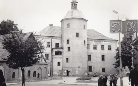 Zamek książąt pomorskich w Słupsku, z charakterystyczną wieżą i arkadowym balkonem, na tle miejskiego krajobrazu.