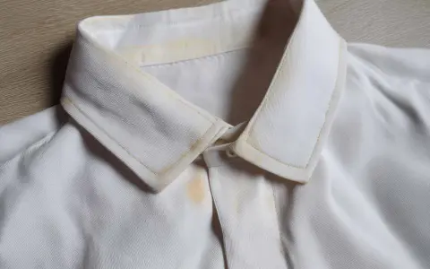 Vergilbter Kragen eines weißen Hemdes, bereit zum hemd bleichen. Gelbe Flecken sind sichtbar.