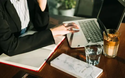 Pracownik biurowy przy laptopie, obok notatnik "To Do List", szklanka wody i kawa. Zastanawia się, ile czasu ma bank na zwrot prowizji.