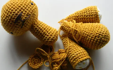 Piezas de amigurumi de One Piece en proceso, con hilo amarillo y detalles bordados.