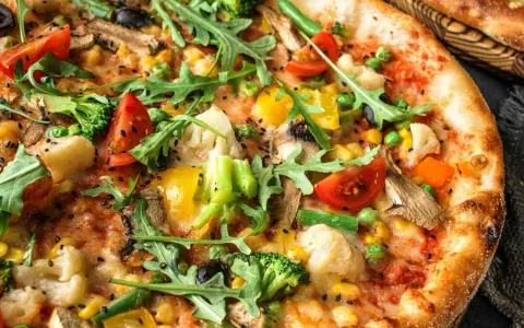 Pyszna pizza bez mięsa z brokułami, pomidorkami, kukurydzą i rukolą. Idealna dla wegetarian.