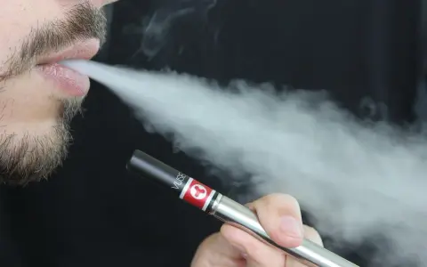 Hombre vapeando con un dispositivo Vuse, exhalando vapor. Una opción para quienes buscan vapers sin nicotina y cuidan su salud.