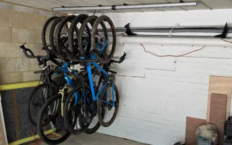 Système de rangement astucieux pour vélos dans un garage, plusieurs vélos suspendus au plafond pour optimiser l'espace.