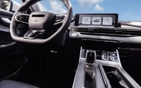 Interior de un coche moderno con volante, pantalla táctil y palanca de cambios. El futuro de los coches autónomos ya está aquí.
