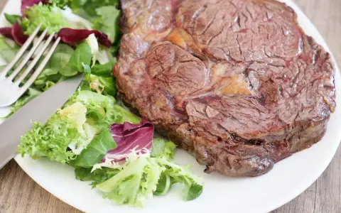 Une succulente côte de bœuf, parfaitement saisie, accompagnée d'une salade fraîche et croquante. Un délice à savourer !