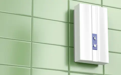 Moderner, weißer Durchlauferhitzer ohne Neutralleiter an einer hellgrünen Fliesenwand. Zwei Drehregler zur Temperatureinstellung.