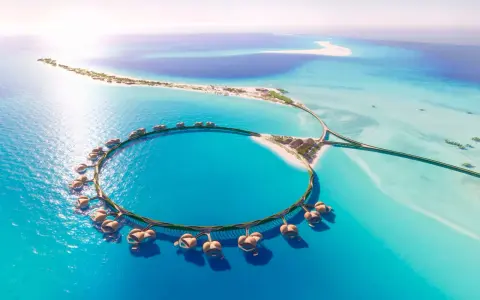 Resort circolare su palafitte nel Mar Rosso Arabia Saudita, con isole sabbiose e acque turchesi.