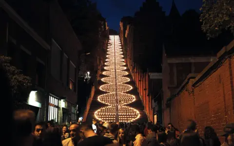 Beleuchtete Treppe in Büren bei Nacht, umgeben von Menschen und Gebäuden.