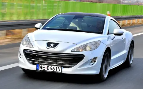 Biały Peugeot RCZ, jeden z francuskich marek samochodów, pędzi po autostradzie.