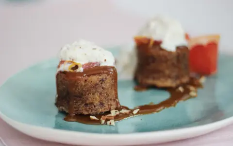 Zwei kleine Kuchen mit Karamellsauce, Nüssen und Sahne. Die süße Glucose-Verwendung macht sie unwiderstehlich.