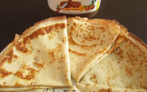 Crêpes dorées prêtes à être garnies, avec un pot de Nutella en arrière-plan. Une recette facile pour des crêpes maison !