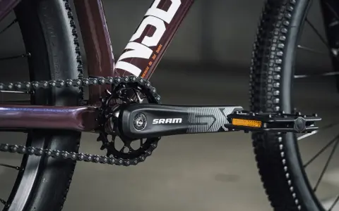 Zbliżenie na rowerowy mechanizm korbowy SRAM i łańcuch. Tabela przełożeń rowerowych jest kluczowa dla płynnej jazdy.