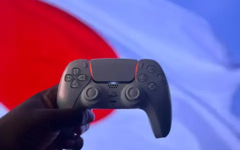 Dłoń trzyma biały kontroler DualSense. Czy gry z PS5 działają na PS4? To pytanie nurtuje graczy.