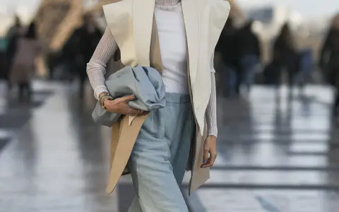 Elegancka stylizacja: jak nosić kamizelkę damską z szerokimi spodniami i błękitną torebką.