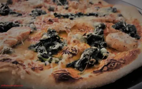 Pyszne ciasto na pizzę Ani Gotuje z kurczakiem i szpinakiem, zapieczone z serem.