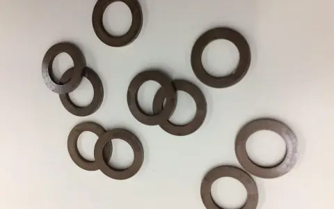 Un gruppo di rondelle alzaporta marroni, usate per regolare l'altezza delle porte.