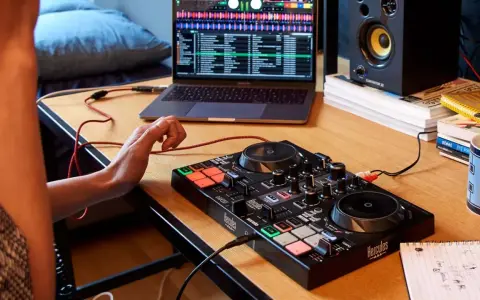 Osoba uczy się, jak zostać DJ-em, ćwicząc na kontrolerze DJ-skim i laptopie z oprogramowaniem muzycznym.