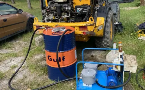 Ważne jest, jak sprawdzić poziom oleju hydraulicznego w koparce. Na zdjęciu widać beczkę Gulf i pompę do uzupełniania płynu.