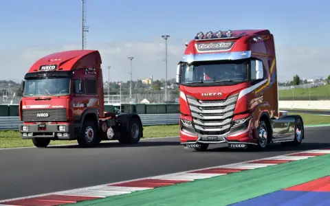 Dos camiones Iveco rojos, uno antiguo y otro moderno, en una pista de carreras.