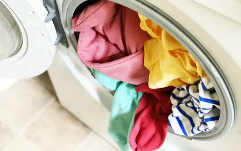 Carga de lavadora con ropa de colores variados, incluyendo rosa, amarillo, turquesa y rayas azules. ¡A ver si se puede lavar ropa blanca con ropa de color sin problemas!