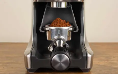 Nahaufnahme des Siebträgers mit frisch gemahlenem Kaffee, bereit zur Einstellung des Sage Smart Grinder Pro.