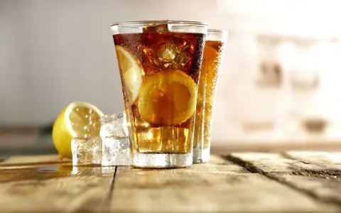 Dwa orzeźwiające long island iced tea z plasterkami cytryny i lodem, gotowe do degustacji.