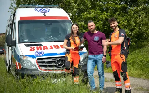 Trzech ratowników medycznych przy ambulansie. Zastanawiasz się, ile zarabia ratownik medyczny?