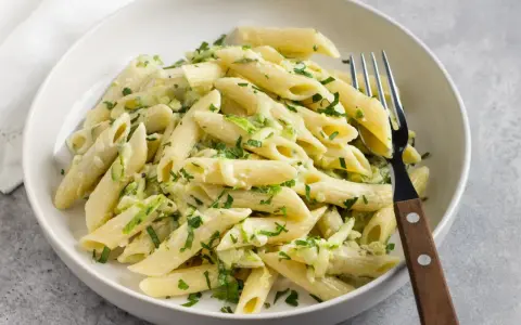 Makaron penne z cukinią i natką pietruszki w białym sosie.