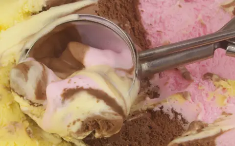 Łyżka do lodów nabiera porcję pysznego, kolorowego gelato. Czy to czekoladowe, truskawkowe, czy waniliowe?