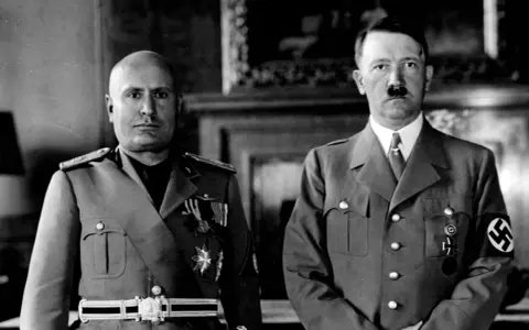 Mussolini och Hitler, symboler för vad fascism betyder, står sida vid sida i militäruniformer.
