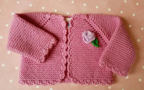 Chaqueta a crochet para bebé de 3 a 6 meses, rosa con flor lila y hoja verde. Ideal para abrigar a tu pequeño con estilo.