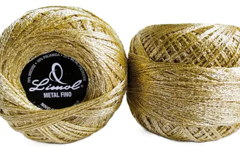Deux pelotes de fil métallique doré, parfait pour ajouter une touche d'éclat aux textiles.