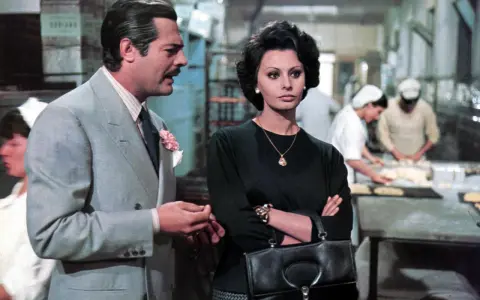 Marcello Mastroianni e Sophia Loren, icone delle commedie all'italiana, in una scena che evoca sapori e storie del cinema.