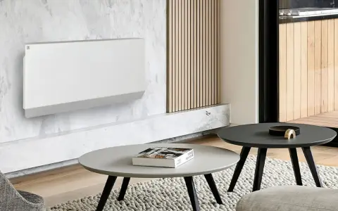 Un moderno termosifone bianco su parete in marmo, un'idea per arredare parete con termosifone in modo elegante. Tavolini e tappeto completano l'arredo.