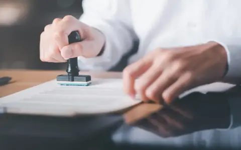 Osoba stempluje dokument. Prace interwencyjne wady i zalety mogą być związane z formalnościami.