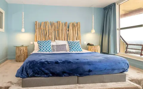 Tête de lit bois à faire soi-même, ambiance bord de mer avec coussins bleus et couverture marine.