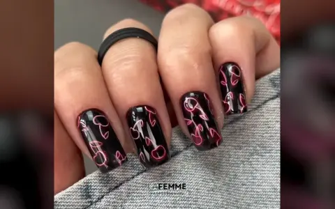 Unghie nere con un vivace disegno di ciliegie rosa neon. Un tocco di dolcezza estiva per le tue mani.