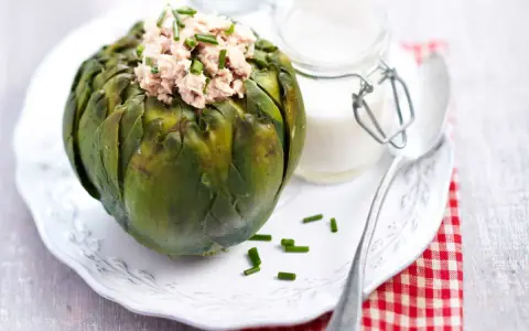 Artichaut farci de thon, garni de ciboulette. Une idée de recette artichaut simple et savoureuse, accompagnée d'une sauce crémeuse.
