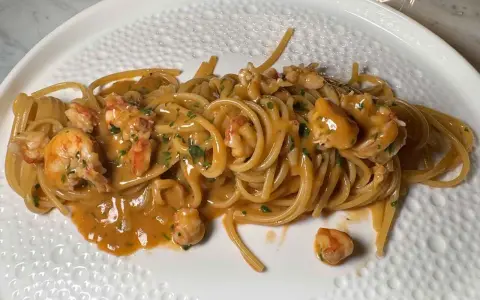 Spaghetti cremosi con mazzancolle e prezzemolo tritato, un piatto invitante e saporito.