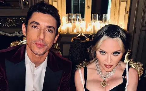 Un uomo con giacca di velluto bordeaux e Madonna con preziosi gioielli, in un'ambientazione suggestiva, forse per l'ultimo spot Dolce e Gabbana.