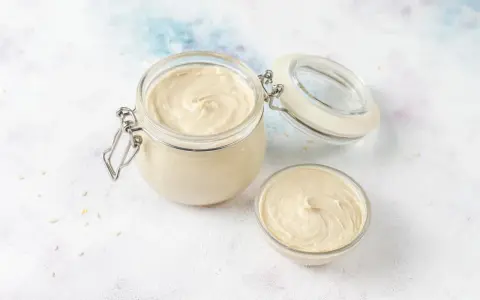 Crème pâtissière onctueuse dans un bocal et un bol. Parfait pour une recette de crème pâtissière facile et rapide.