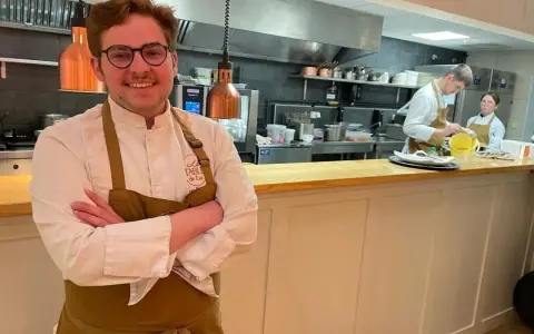 Le chef souriant du restaurant Le Mans, avec son équipe en cuisine.