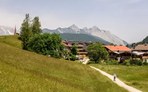 Ein Wanderweg führt durch blühende Wiesen zum malerischen Seefeld. Ein echter Geheimtipp mit Bergblick und traditioneller Architektur.