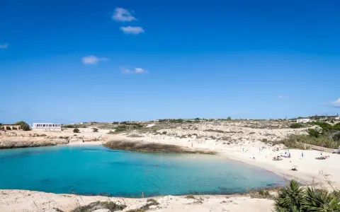 La **Cala Croce a Lampedusa** offre acque cristalline e una spiaggia dorata, ideale per rilassarsi sotto il sole.