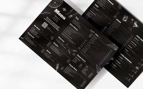 Czarne menu z białymi napisami i grafikami. Czy warto personalizować menu pod kątem graficznym dla każdego gościa? To pytanie nabiera sensu, gdy widzimy tak stylowe propozycje.