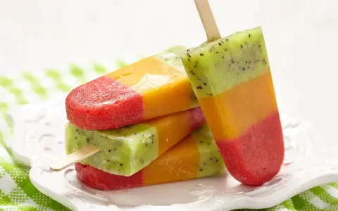 Kolorowe lody na patyku: truskawka, mango i kiwi. Idealne na lato, gdy szukasz prawdziwe lody przepis.